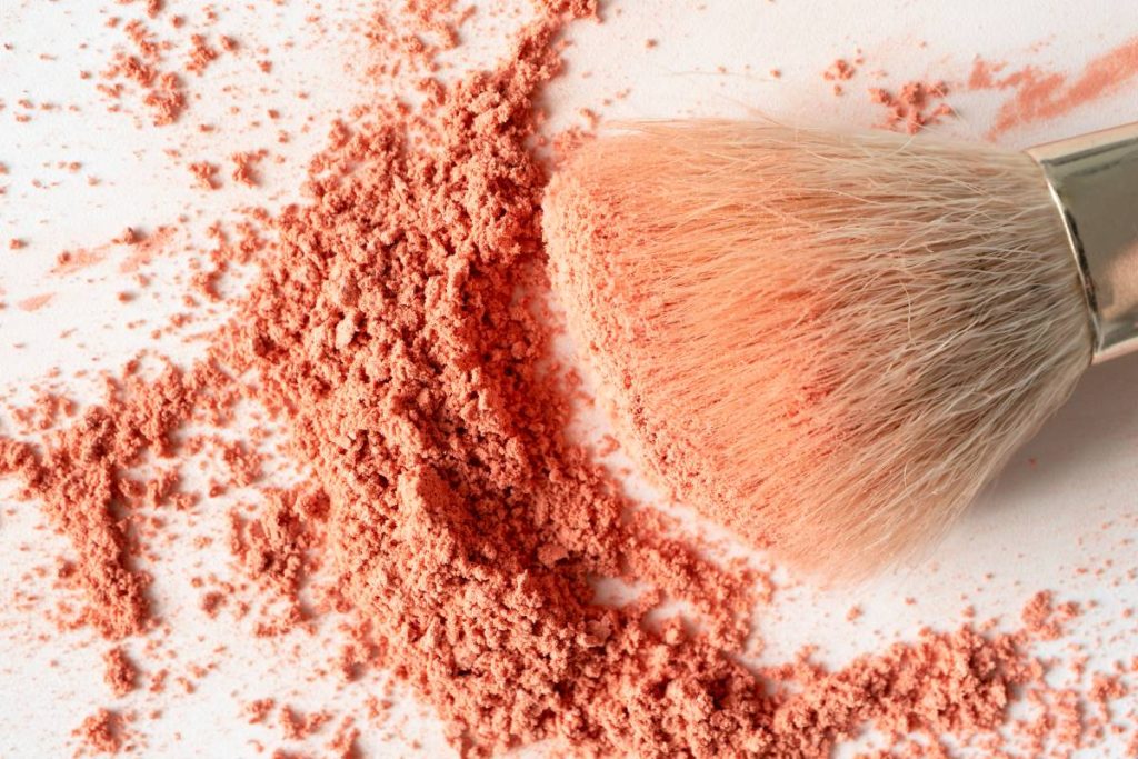 Face blusher powder and make-up brush on white background close-up, top view. Detail decorative cosmetic