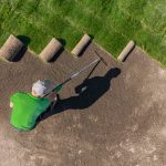 Man Installing Grass Turfs on a Golf Course Aerial View.